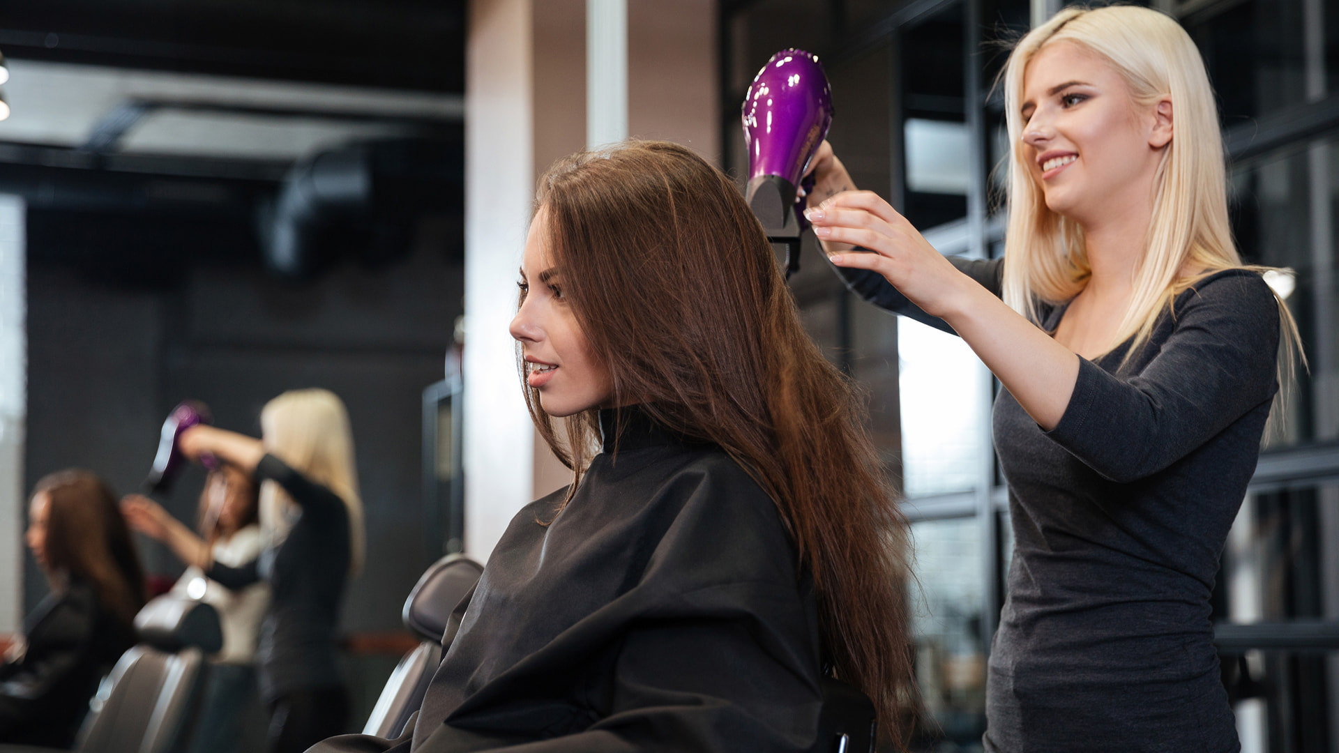 Stylist blow drying hair