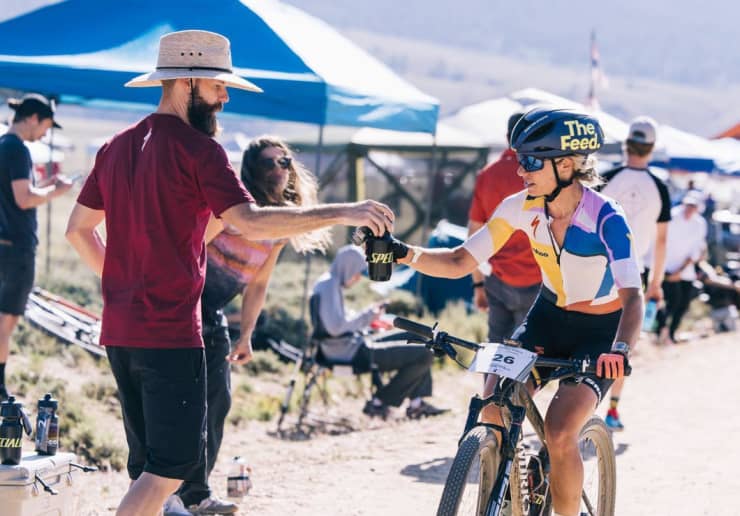 Triathlete in an aero position on a bike, wearing a The Feed aero helmet