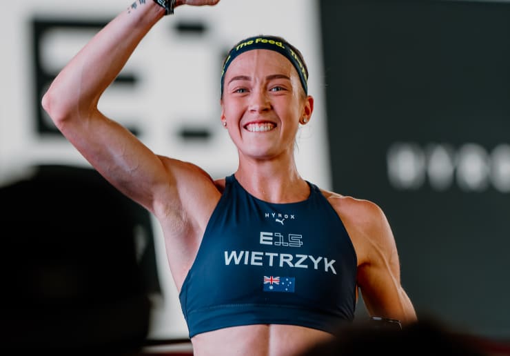 Triathlete in an aero position on a bike, wearing a The Feed aero helmet