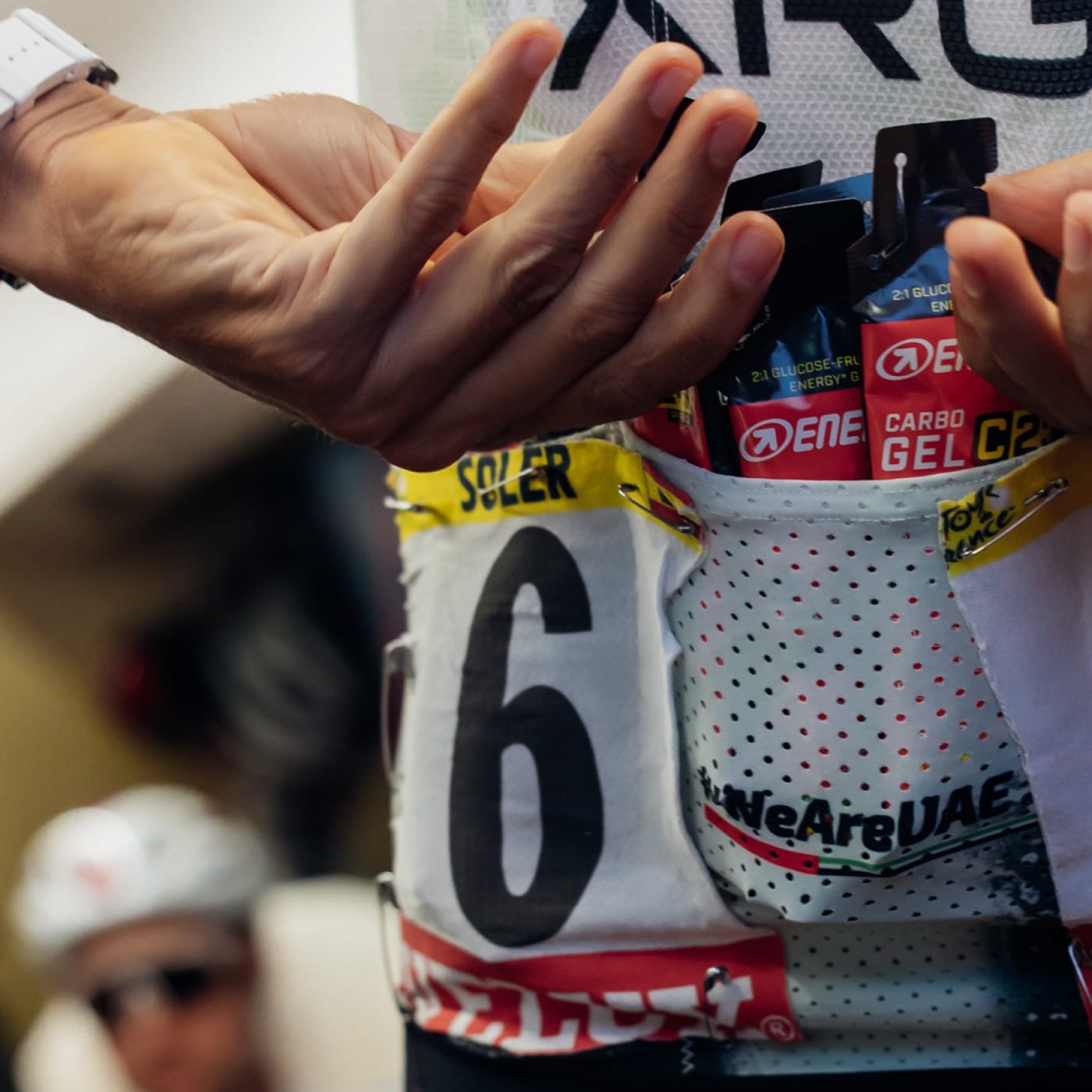 Cyclist jersey pockets filled with Enervit Carbo Gel packets during race