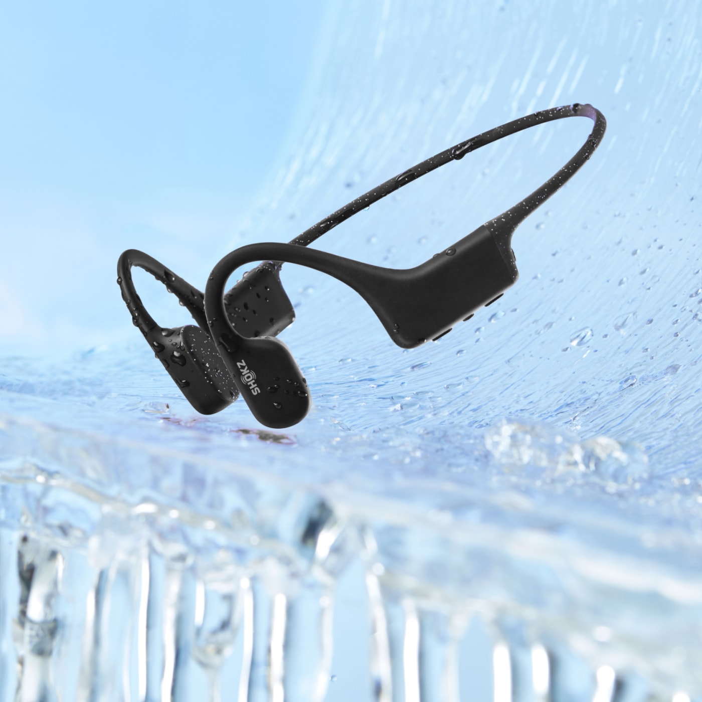 Shokz open-ear bone conduction headphones resting on ice, waterproof design for cold-weather workouts and outdoor sports