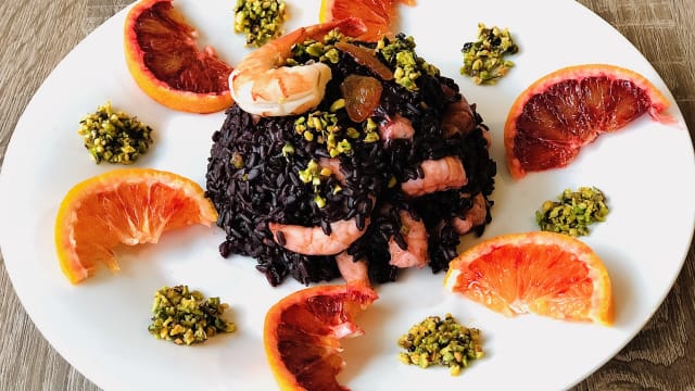 Riso venere con gamberi, succo e scorzette d'arancia, granella di pistacchio