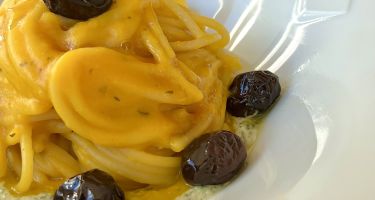 Spaghetti con crema di zucca, pesto cremoso di semi di zucca e olive in agrodolce