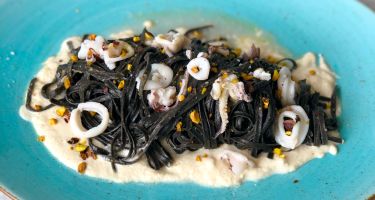 Tagliolini al nero di seppia, bisque in bianco di gamberoni, calamaretti su crema di mandorle