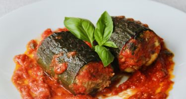 Zucchine al sugo ripiene di carne, formaggio ed erbe aromatiche