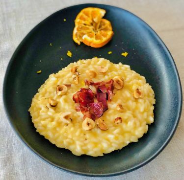 Risotto cremoso alle clementine, nocciole tostate e bacon di manzo croccante