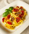 Pasta con crema di pomodorini gialli e acciughe, pomodorini confit e mollica di pane