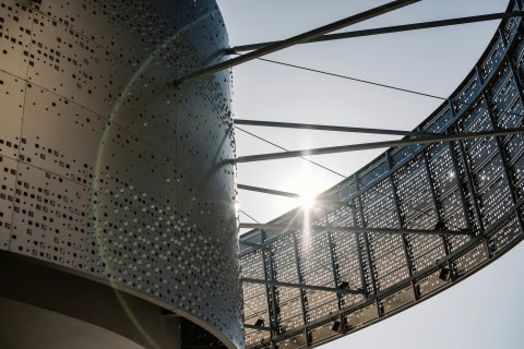Sunlight passing through a perforated architectural steel bridge