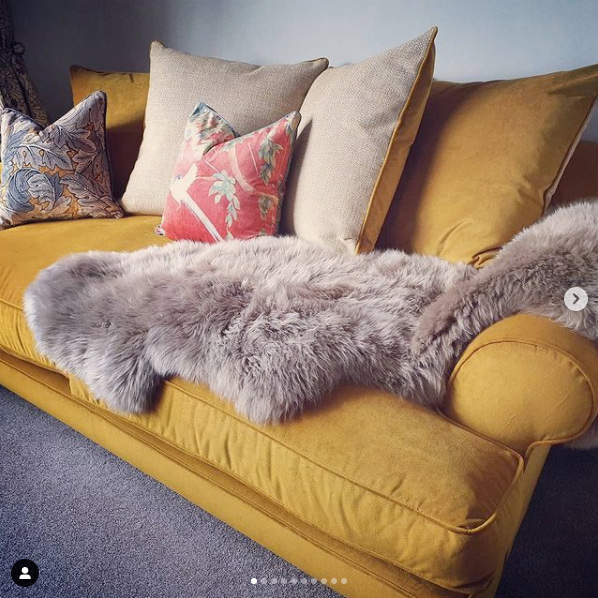 Mustard velvet sofa with patterned red cushions