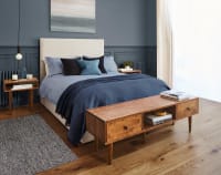 Bedroom double bed with navy throw and wooden end table