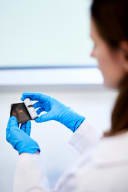 Photo of an Elysia electrochemist looking at a lithium ion battery