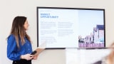 Women stood infront of a large TV presenting research insights and market opportunities