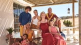 Large family photoshoot, sat on a outdoors dining table