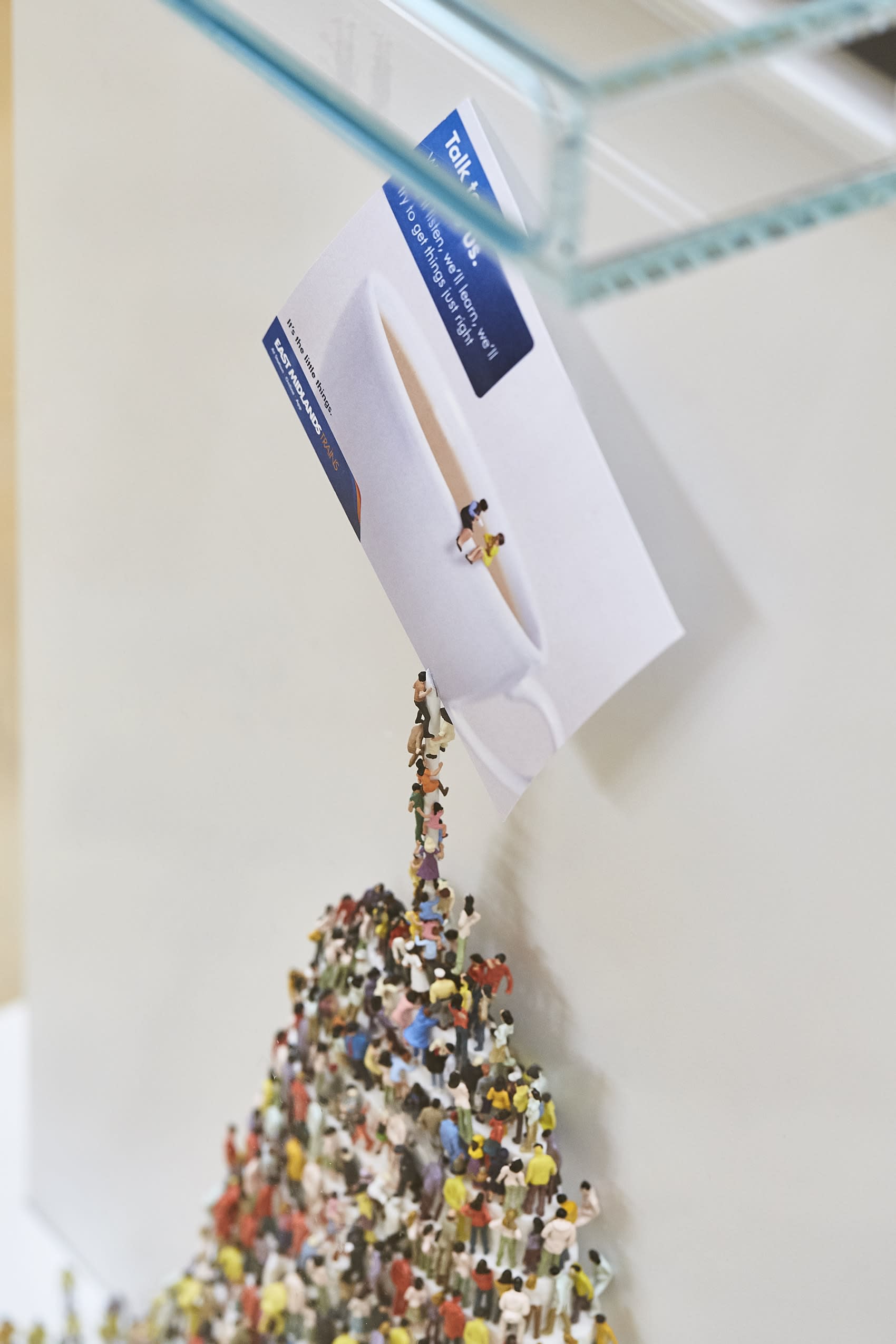 Toy people climbing to reach East Midlands Trains card