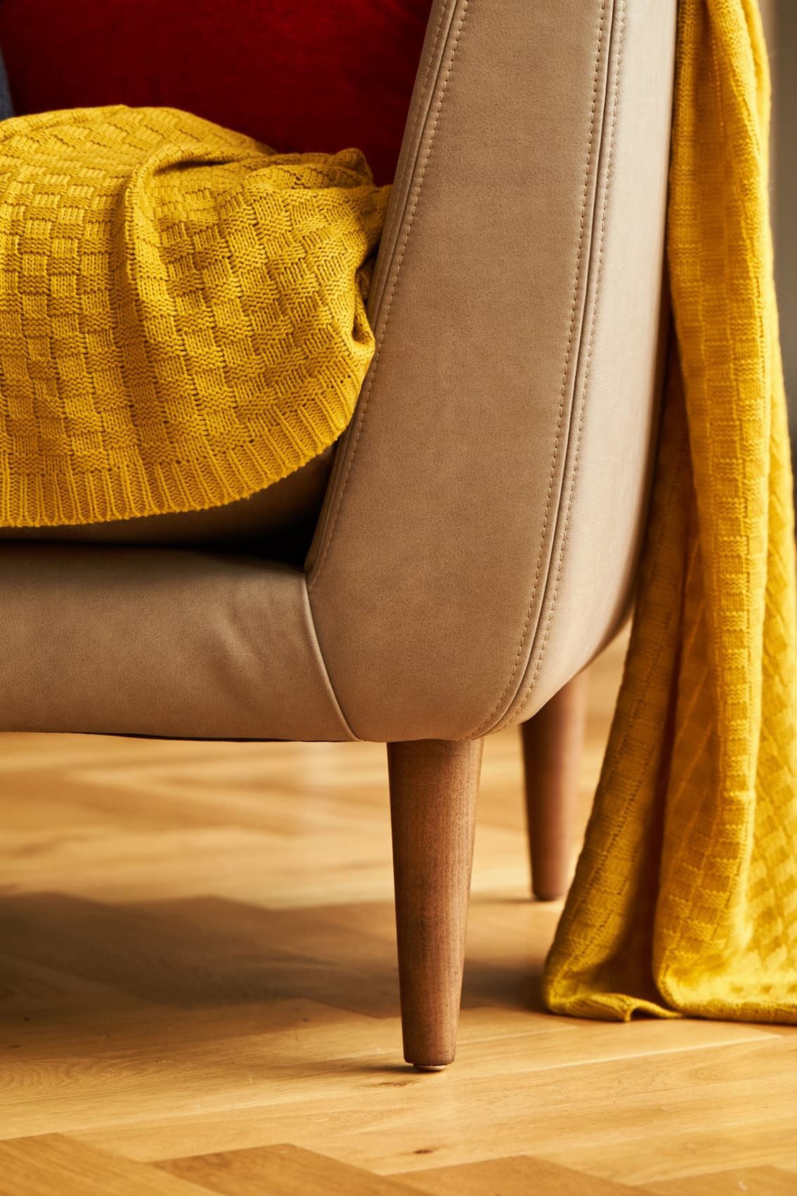 Brown leather sofa with mustard throw