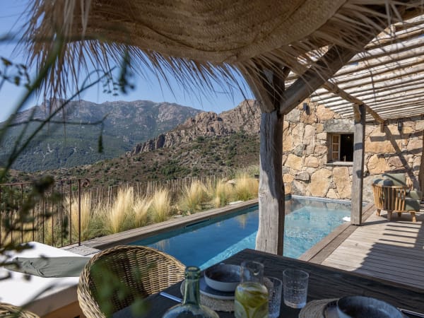 The shady dining area by the pool is served by a plancha grill, workspace and a sink.