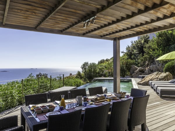 The shady al fresco dining area overlooks the pool and the sea.
