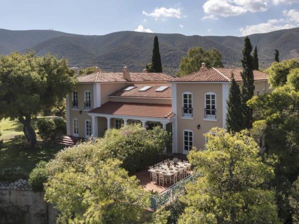 The two wings of Villa Aetos's main house rising amidst a verdant canopy.