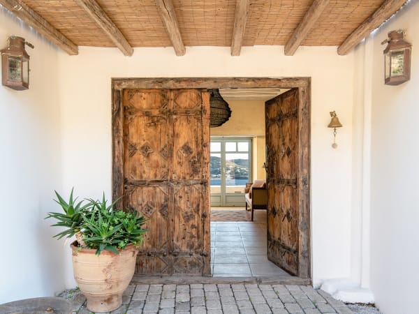A pair of venerable wooden doors welcome guests to the main house.