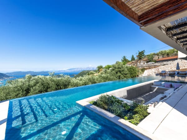 Villa Galinia's infinity pool incorporates a sunken sitting area and three sections wrapping around and in between the house.