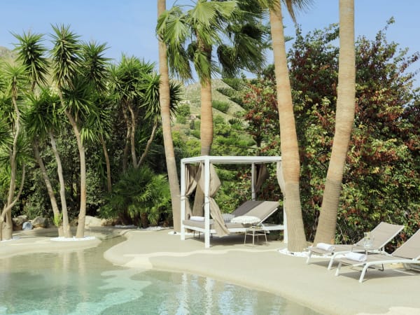 A shallow, beach-shelf links the main part of the pool to a hydromassage section. 