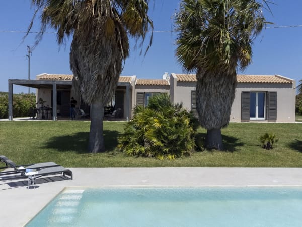 Belich seen from the pool, with its pair of venerable palm trees standing to attention.