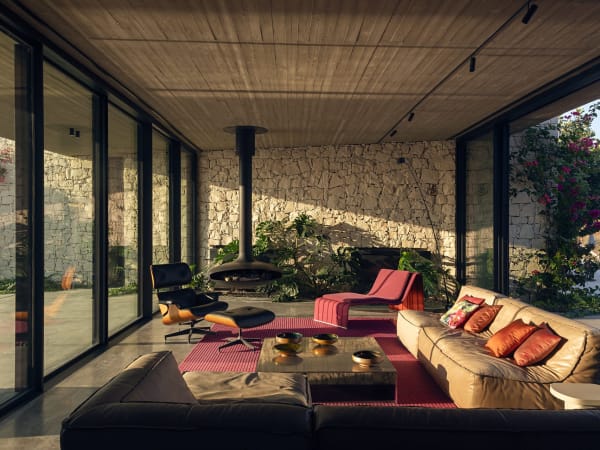 The beautifully furnished living area with its iconic suspended fireplace has views out over the olive groves to Vendicari Nature Reserve.