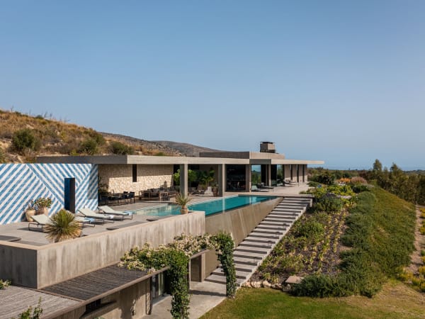 Steps lead down below the pool's infinity edge to the accommodation on the lower level.