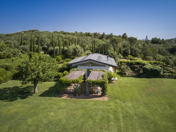 The main house of La Bandita framed by the estate's woodland.