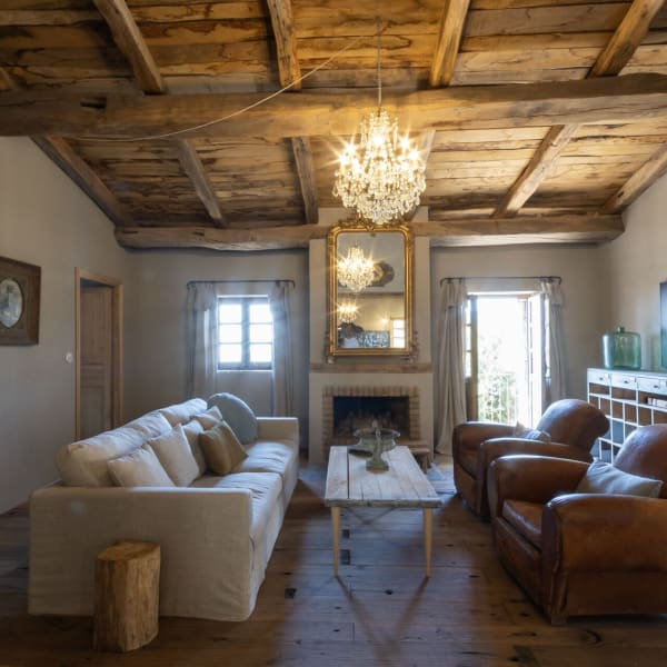 The warm, welcoming living area, with its lofty wood-beamed ceiling, fireplace and soulful atmosphere.