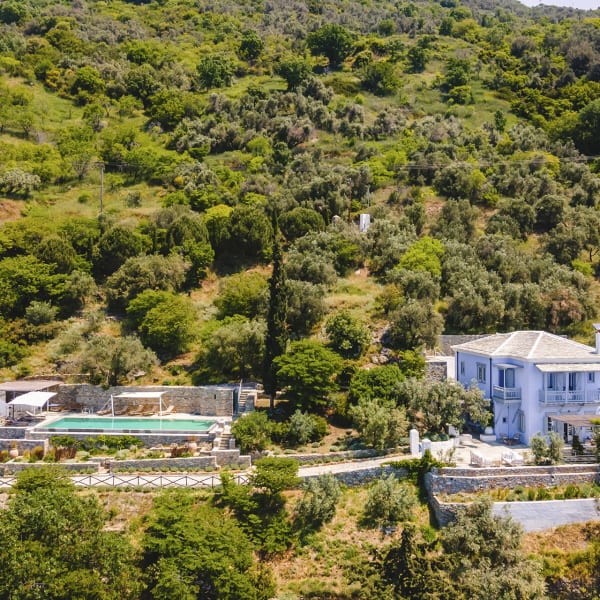 Blue House rising serenely on the verdant coastline of northwest Skopelos.