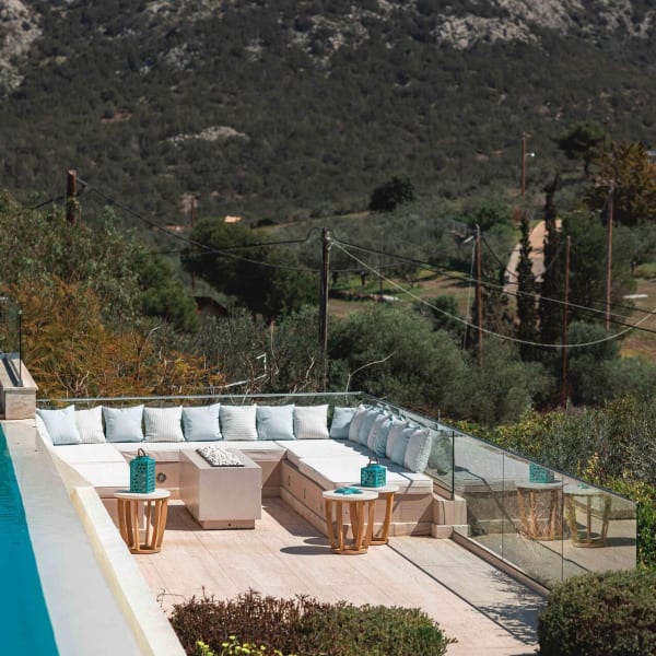 The lounge area below the pool has well-cushioned seating and a firepit.