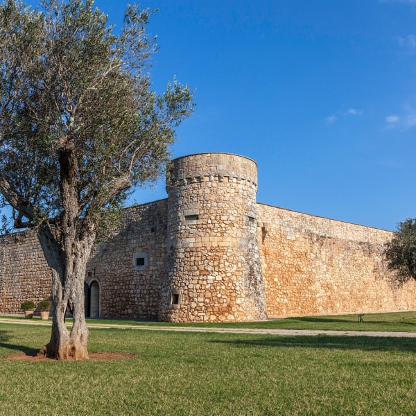The impressive walls of Castello di Caprarica seen from the gardens.