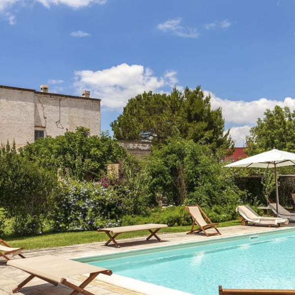 The pool, gardens and the imposing façade of Villa Elia rising behind.