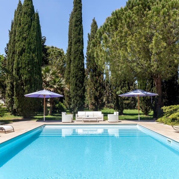 The beautiful pool at Villa Specchia is surrounded by mature trees. 