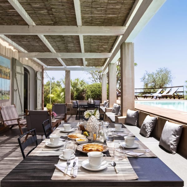 The poolside terrace is furnished for dining and relaxing.