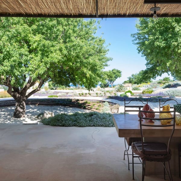 The al fresco dining area at Tenuta Baroniblei with its calming garden views.