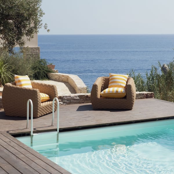 A panoramic sitting area between the pool and the sea.