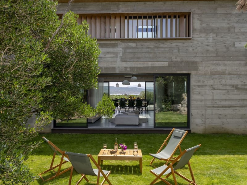 Looking through the main house's communal space from the second al fresco dining area, a secluded spot embraced by greenery.