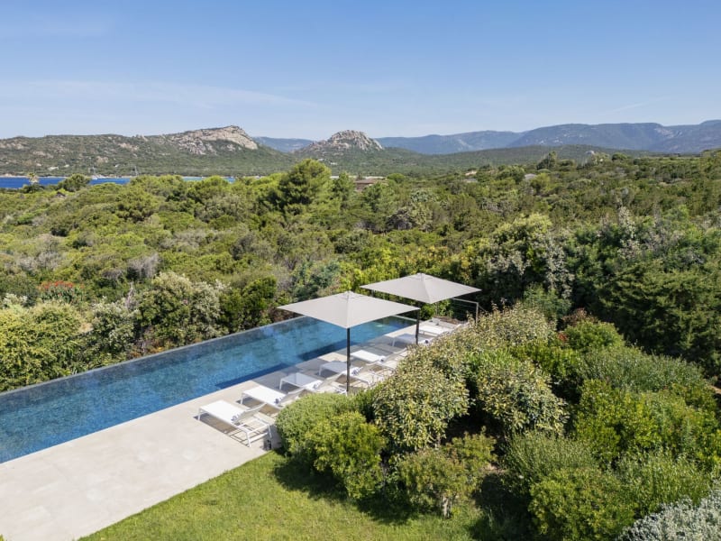 The beautiful heatable infinity pool at Sintineddu is surrounded by greenery.