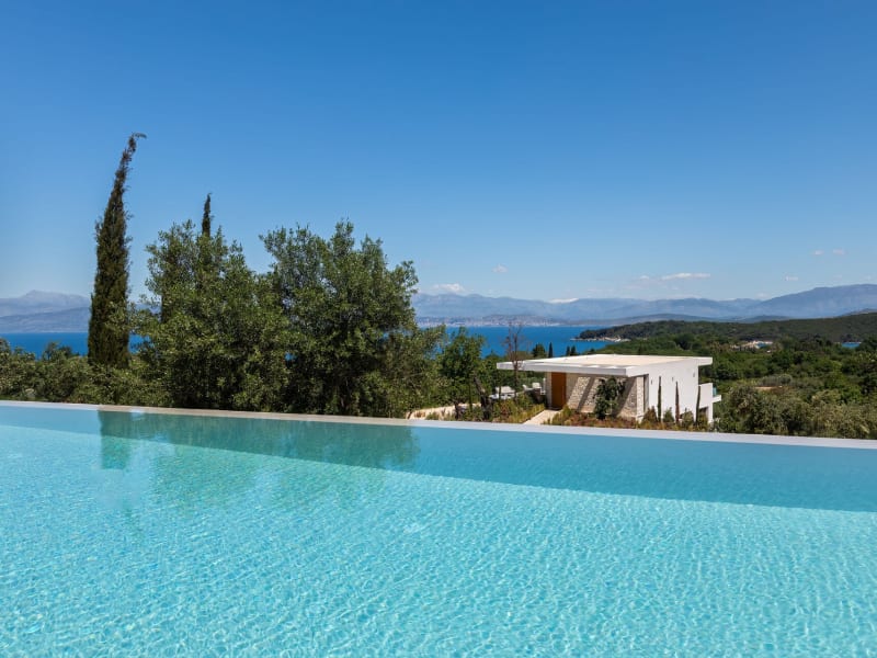 Views from the heatable infinity pool take in the house, the green hills of northeast Corfu, the sea, and Albania on the horizon.