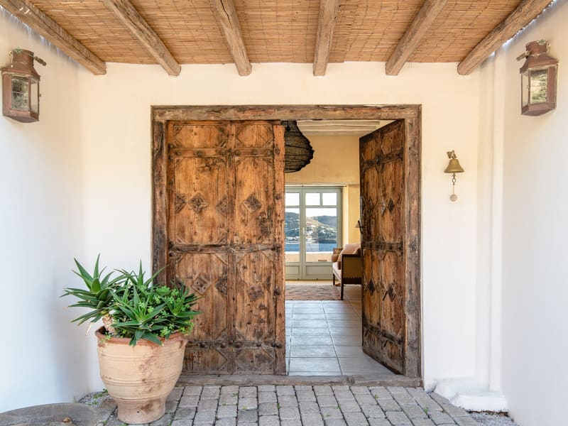 A pair of venerable wooden doors welcome guests to the main house.