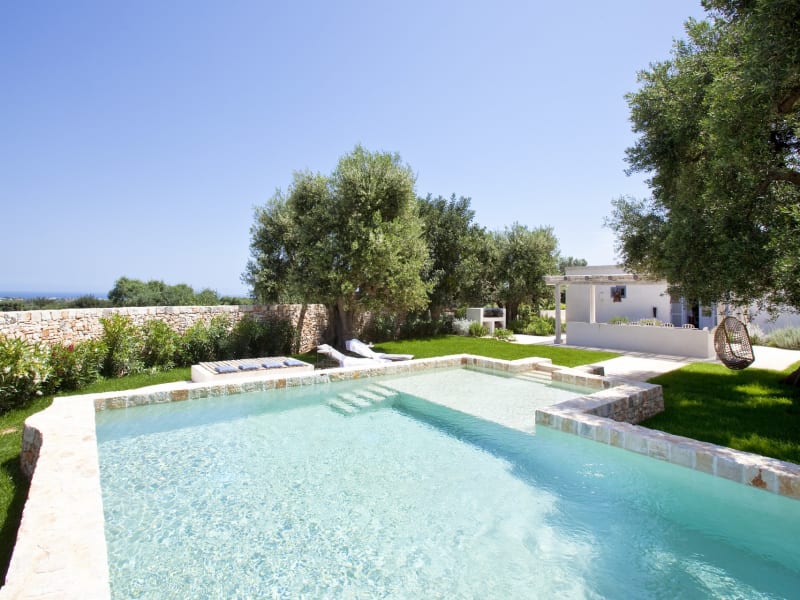 Trullo Alice's beautiful pool and gardens with the sea just visible on the horizon.