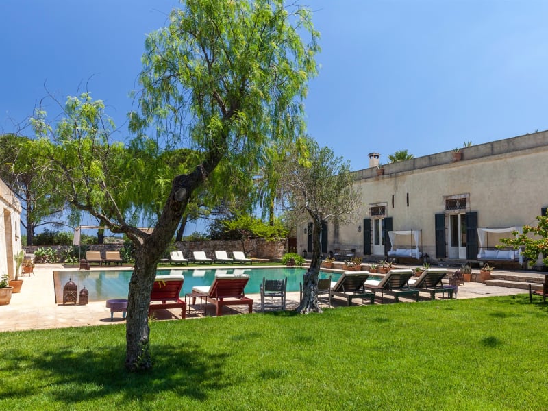 Large expanses of lawn surround the pool and the house.