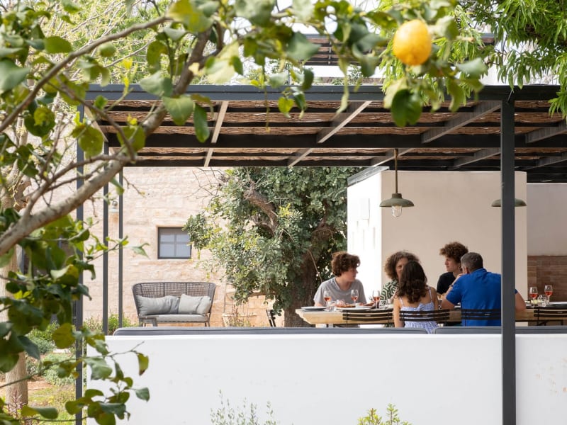 The main al fresco dining area is flanked by a sitting area and served by a barbecue.