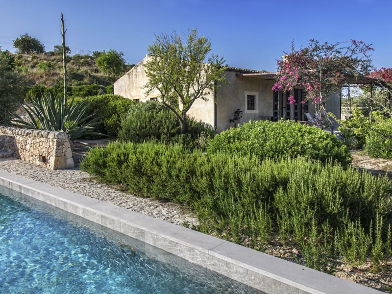 The pool with the house seen behind.