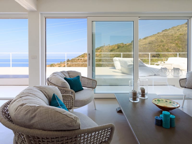 The bright sitting and dining area with its banks of sliding glass doors.