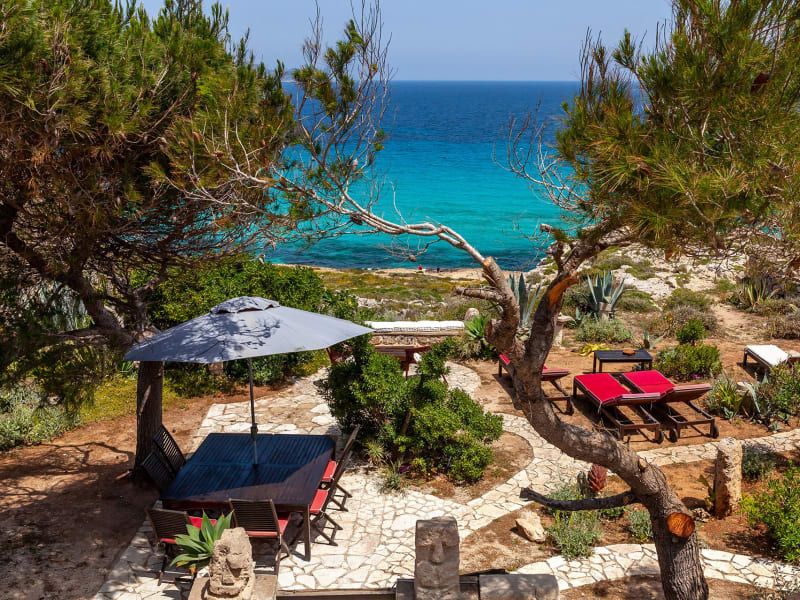 The private garden overlooking Cala Rossa has a dining area and barbeque.