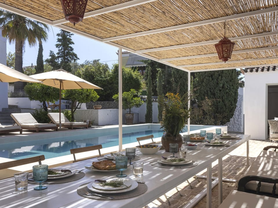 The al fresco dining area outside the pool house is perfect for convivial moments.