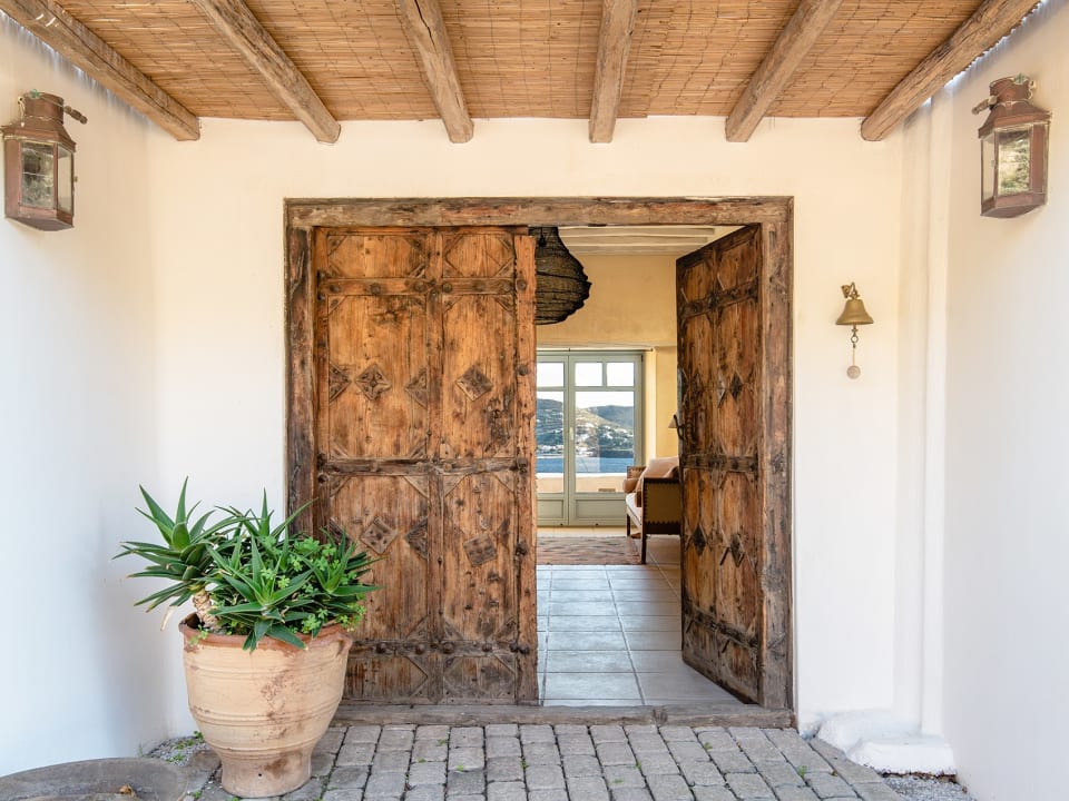 A pair of venerable wooden doors welcome guests to the main house.